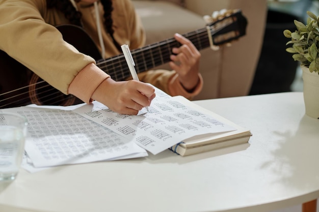 Garota praticando exercícios para aula de violão