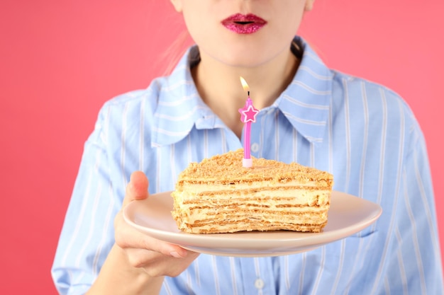 Garota quer apagar a vela no fundo rosa fechar