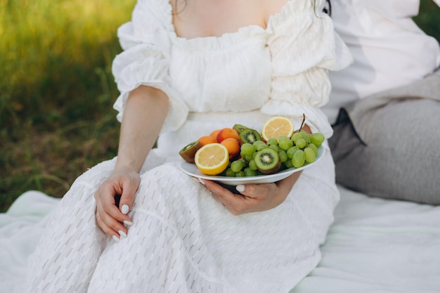 Garota relaxando e comendo prato de frutas à beira da piscina do hotel Dieta exótica de verão Foto de pernas com comida saudável à beira da piscina vista superior de cima Estilo de vida de praia tropical