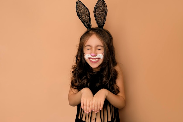 Garota rindo engraçada com orelhas de coelho e rosto pintado Coelho é símbolo da Páscoa