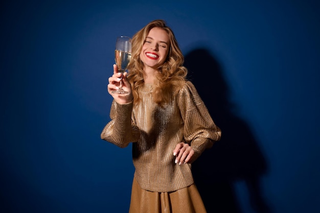 Garota rindo segurando uma taça de champanhe para a câmera