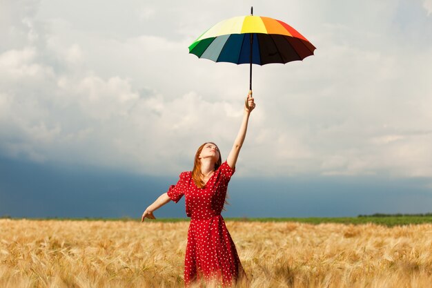 Garota ruiva com guarda-chuva no campo