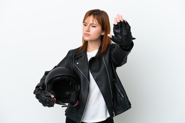Garota ruiva com um capacete de moto isolado no fundo branco fazendo gesto de parada e decepcionado
