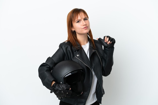 Garota ruiva com um capacete de moto isolado no fundo branco orgulhoso e satisfeito