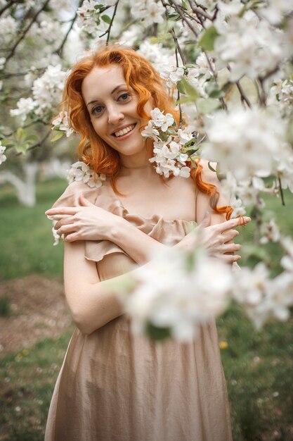 Garota ruiva em um vestido bege no jardim