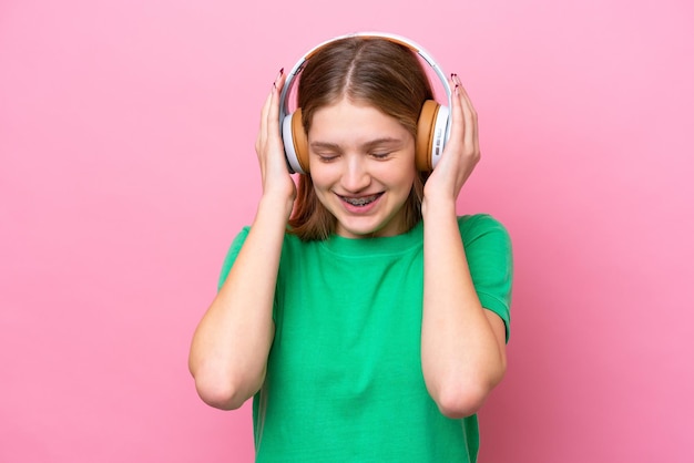 Garota russa adolescente isolada em fundo rosa ouvindo música