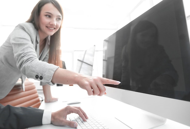 Garota satisfeita está apontando para uma tela de monitor em branco