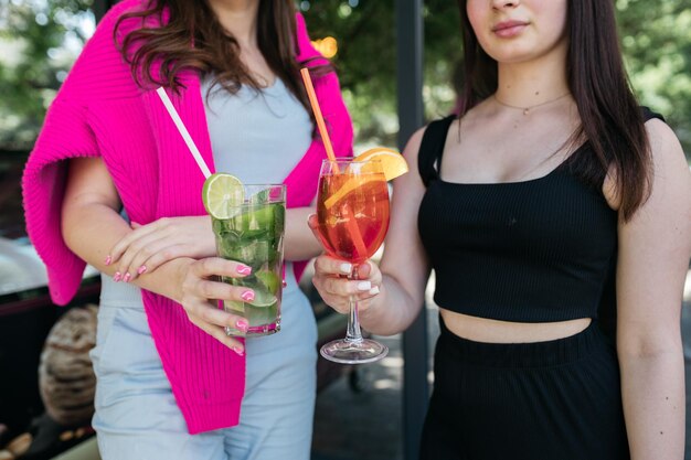 Garota segurando coquetéis em suas mãos Garota segurando Aperol e Mojito em suas mãos Horário de verão Calor