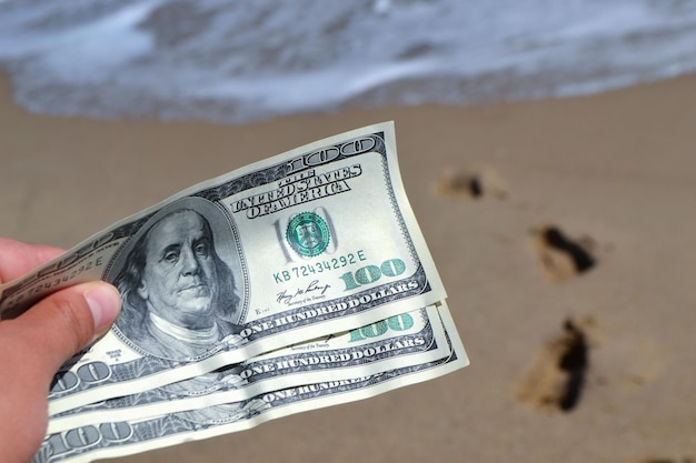 Foto garota segurando nota de dinheiro de 300 dólares no fundo do oceano do mar