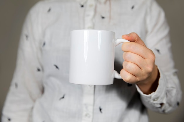 Garota segurando uma caneca de café branca em branco caneca de porcelana branca simulando café chá leite ou espaço de cópia de refrigerante