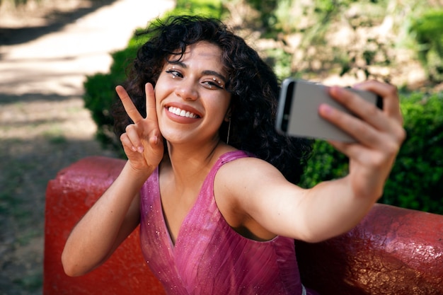 Garota sorridente de tiro médio tomando selfie