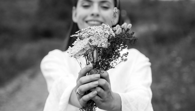 Garota sorridente primavera em campo estilo de vida saudável mulher em prado com campo orgânico de flores silvestres