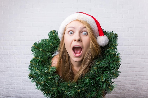 Garota surpresa e chocada com uma decoração de Natal Grande angular