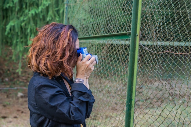 Garota tirando uma foto com uma câmera instantânea