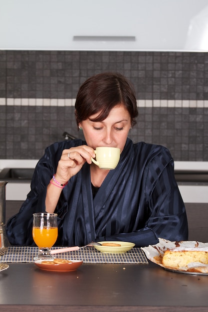 garota tomando café na cozinha