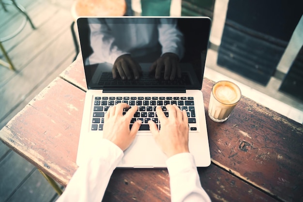 Garota trabalhando com laptop em um café com uma xícara de café