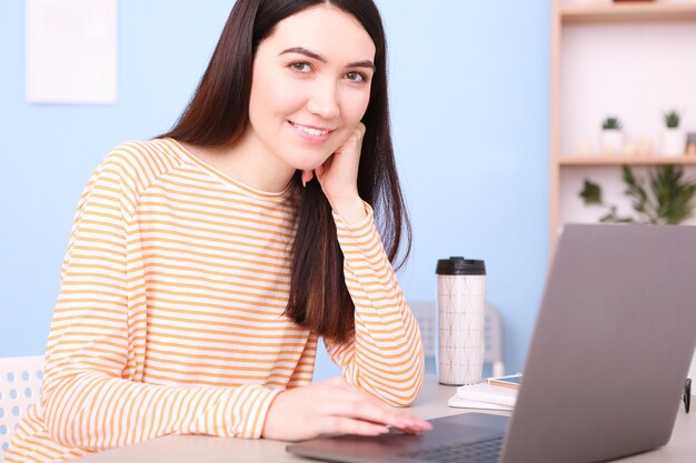 Garota trabalhando em um laptop em casa