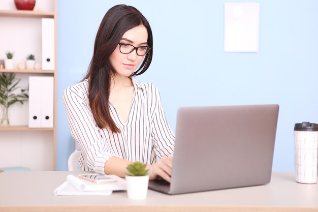 Garota trabalhando em um laptop em casa