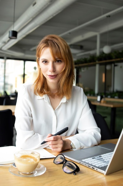 Garota trabalhando em um laptop em um café