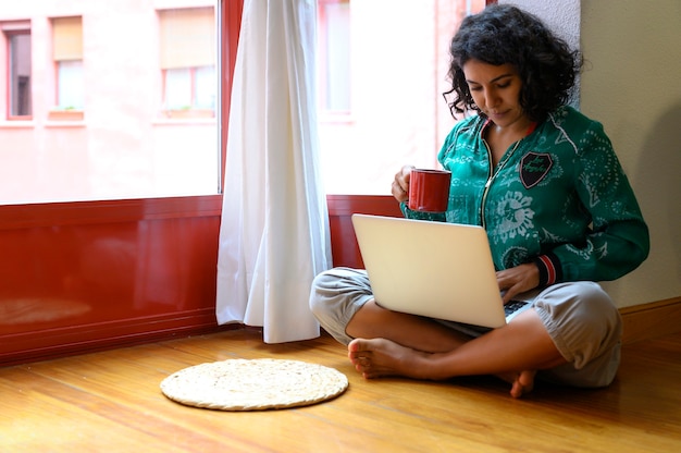 Garota trabalhando no laptop em casa ou estudante estudando em casa ou freelancer.