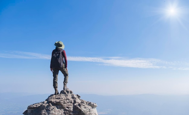 Garota turista com mochila em pé na pedra na montanha, usar chapéu e vista panorâmica no parque nacional pha mak dook phukradung na tailândia.