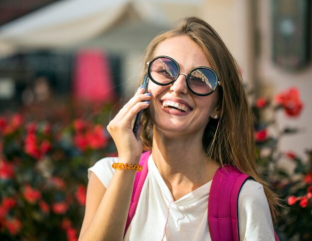 Garota turista feliz falando ao telefone