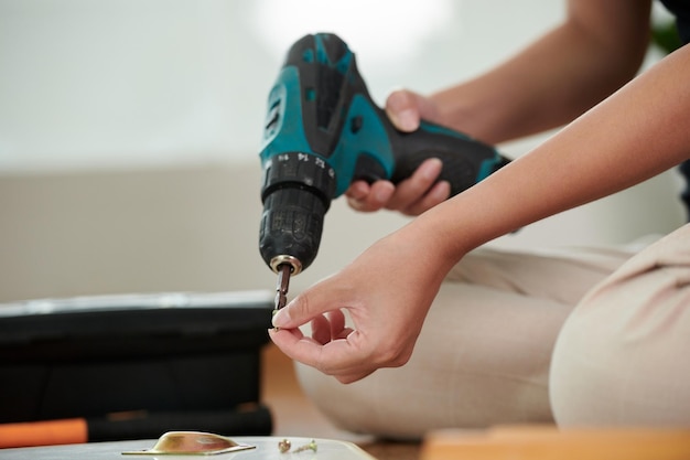 Garota usando broca para fazer reparos