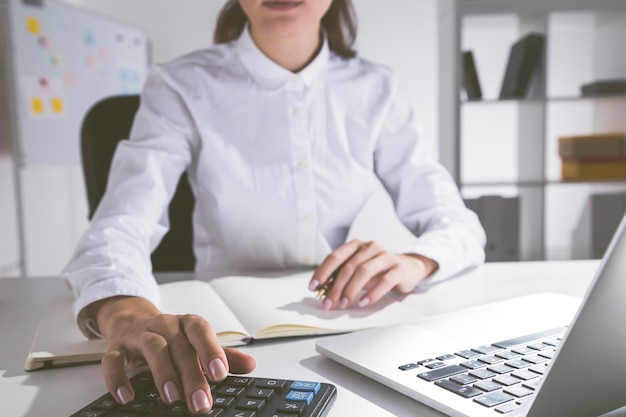 Garota usando calculadora no escritório