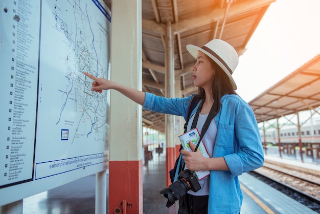 Garota ver o mapa de viagem de trem.