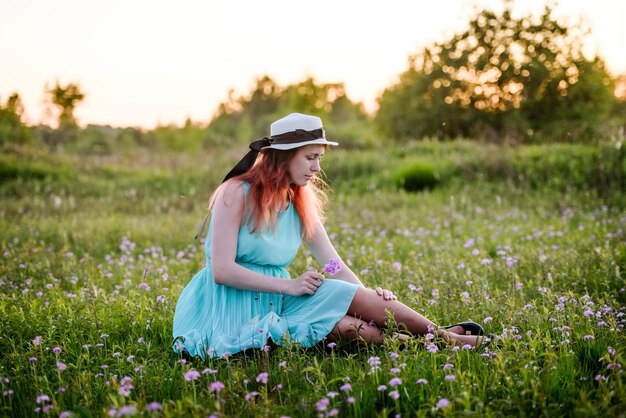 Garota verão o conceito de estilo de vidajovem no campo com flores