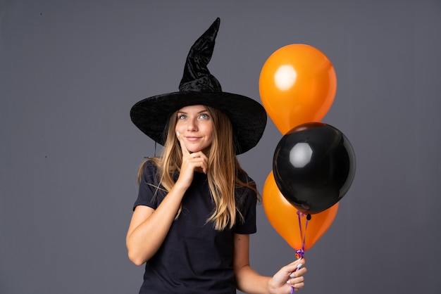 Garota vestida como uma bruxa para o halloween e tendo dúvidas