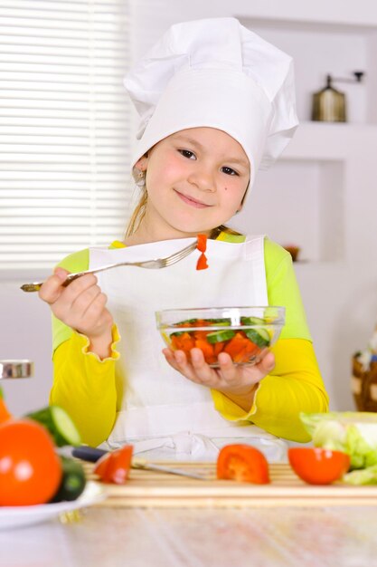 Garota vestindo uniforme de chef cozinhando na cozinha