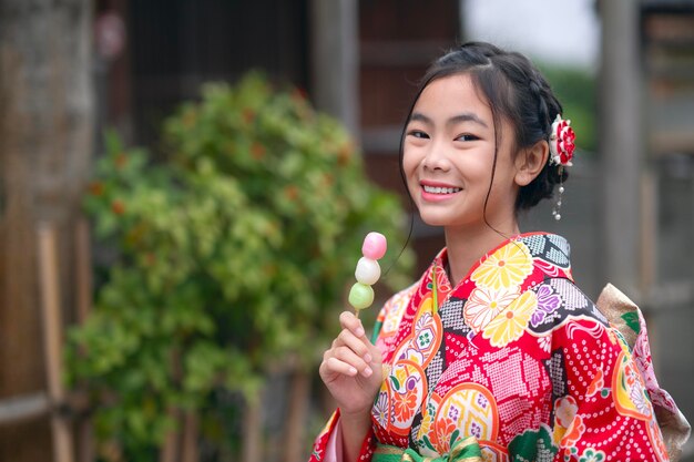 Foto garota viajante asiática em vestido tradicional de quimono andando no antigo templo na cidade de kyoto, japão