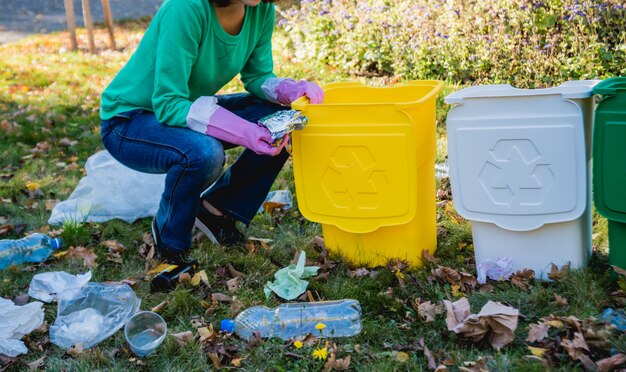 Garota voluntária classifica lixo nas ruas do parque. Conceito de reciclagem.