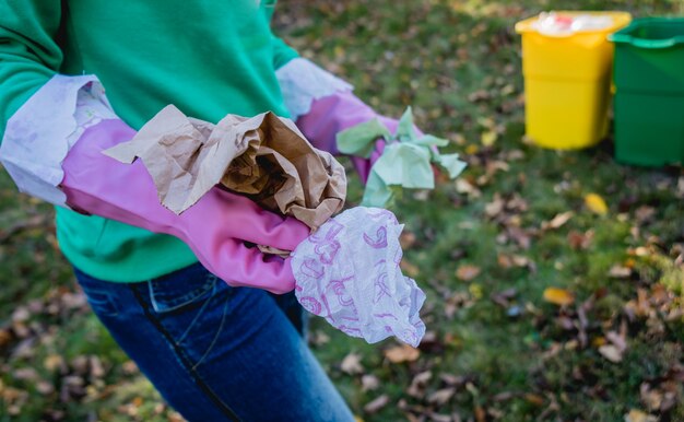 Garota voluntária classifica lixo nas ruas do parque. Conceito de reciclagem.