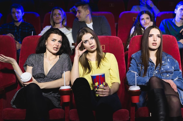 Garotas assistindo a um filme muito chato no cinema filme ruim