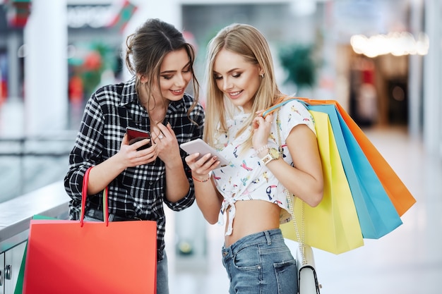 Garotas bonitas posando enquanto fazem compras