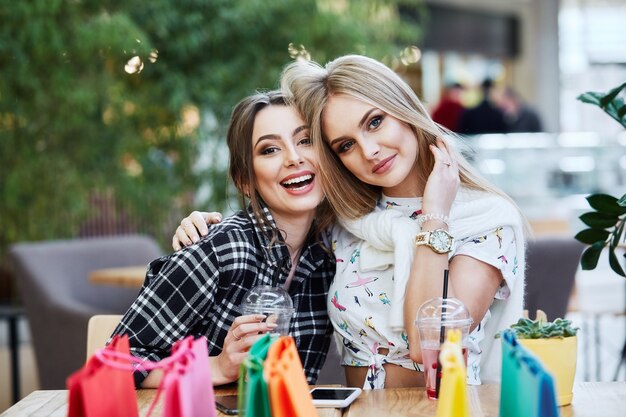 Garotas bonitas posando enquanto fazem compras