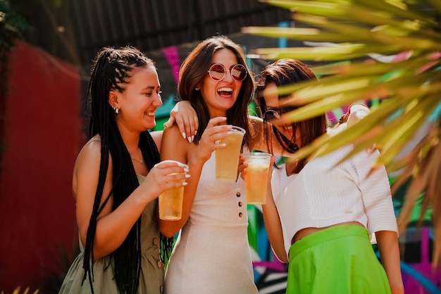 Garotas conversam e bebem coquetéis no terraço de verão, foto do estilo de vida