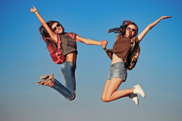 Garotas felizes pulando no céu