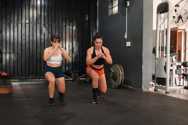 Garotas fitness realizando estocadas na academia