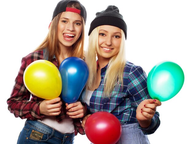 Garotas hipster sorrindo e segurando balões coloridos