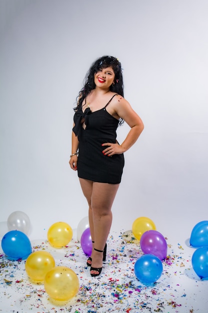 Foto garotas latino-americanas posando e comemorando o ano novo com balões e confetes