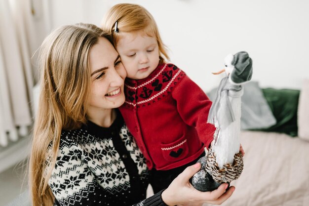 Garotinha e mãe se divertindo e brincando em casa com um interior de Natal O novo ano de 2021 e o conceito de infância