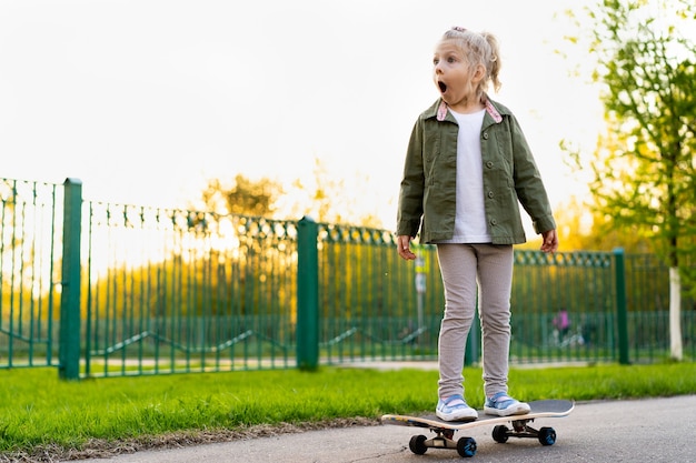 Garotinha loira de skate na cidade.