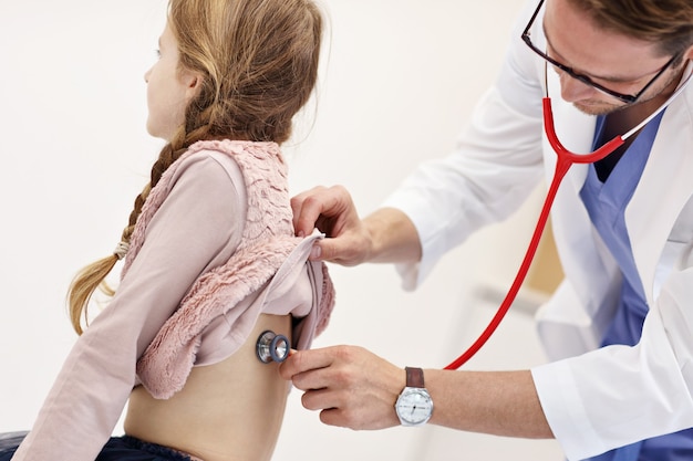 garotinha na clínica sendo examinada pelo pediatra