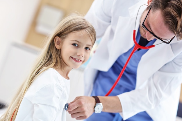 garotinha na clínica sendo examinada pelo pediatra