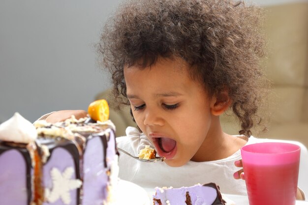 Garotinha negra comendo um bolo