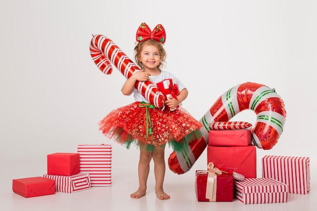 Garotinha sorridente de vista frontal rodeada de elementos de natal