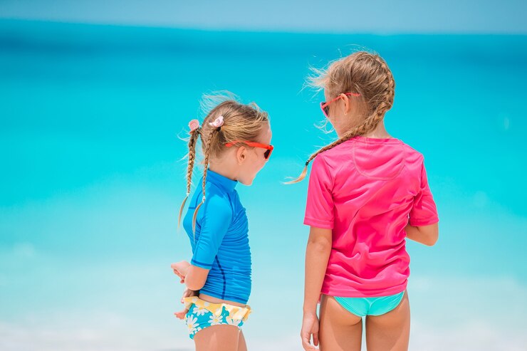 Foto garotinhas engraçadas felizes se divertem muito na praia tropical brincando juntas.